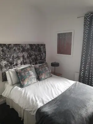 a bedroom with a white bed with a headboard at Cottage terrace Blackpool in Blackpool