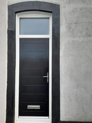 a black door on a building with a window at Cottage terrace Blackpool in Blackpool