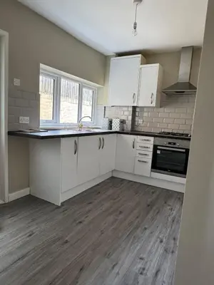 an empty kitchen with white cabinets and a counter top at Homely 3 bedroom House in Liverpool in Liverpool