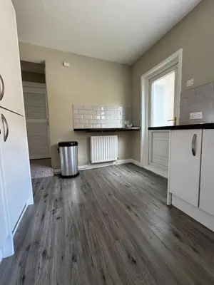an empty kitchen with wooden floors and a window at Homely 3 bedroom House in Liverpool in Liverpool