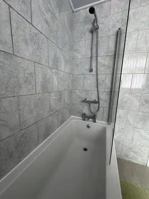 a white bath tub in a bathroom with a shower at Homely 3 bedroom House in Liverpool in Liverpool