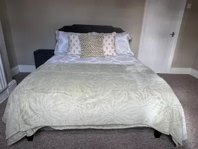 a bed with pillows and a comforter on it at Homely 3 bedroom House in Liverpool in Liverpool