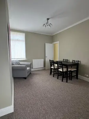 a living room with a table and chairs and a couch at Homely 3 bedroom House in Liverpool in Liverpool