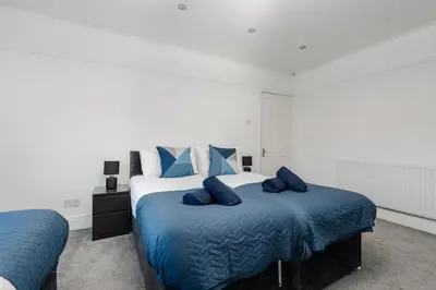 a bedroom with a large bed with blue pillows at Spacious 3BR Sleeps 8 Ideal for Contractors or Large groups in Liverpool