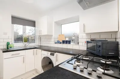a kitchen with white cabinets and a stove top oven at Spacious 3BR Sleeps 8 Ideal for Contractors or Large groups in Liverpool