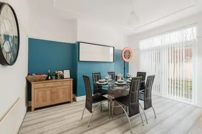 a dining room with a table and black chairs at Spacious 3BR Sleeps 8 Ideal for Contractors or Large groups in Liverpool