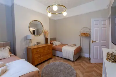 a bedroom with two beds and a mirror at #104 Luxury 4 bed beautiful house in Liverpool in Liverpool