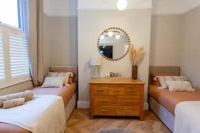 a bedroom with two beds and a mirror and a dresser at #104 Luxury 4 bed beautiful house in Liverpool in Liverpool
