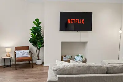 a living room with a couch and a tv on the wall at Spacious 2 Bed Apartment With Secure Free Parking in Liverpool