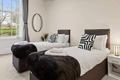 a bedroom with two beds and a mirror at Spacious 2 Bed Apartment With Secure Free Parking in Liverpool