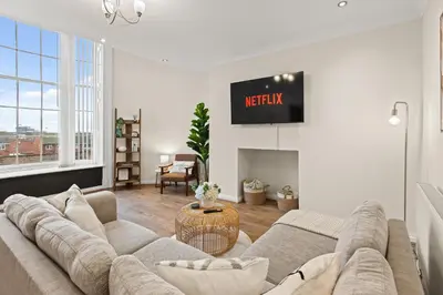 a living room with a couch and a tv at Spacious 2 Bed Apartment With Secure Free Parking in Liverpool