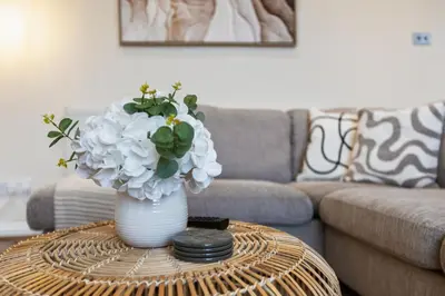a vase with flowers on a table in a living room at Spacious 2 Bed Apartment With Secure Free Parking in Liverpool