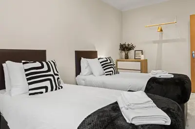 two beds with black and white pillows in a room at Spacious 2 Bed Apartment With Secure Free Parking in Liverpool