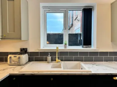 a kitchen counter with a sink and a window at Sleeps 12 TV in Every Room 6 Bedrooms in Liverpool