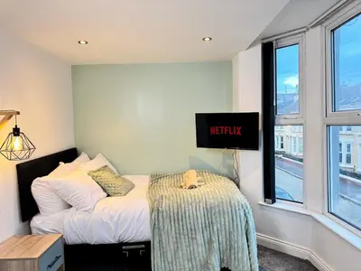 a bedroom with a bed and a sign on the wall at Sleeps 12 TV in Every Room 6 Bedrooms in Liverpool