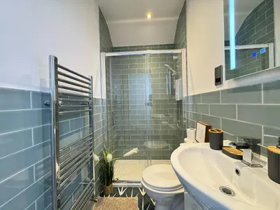 a bathroom with a toilet and a sink and a shower at Sleeps 12 TV in Every Room 6 Bedrooms in Liverpool