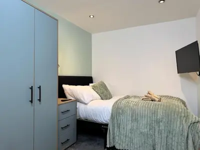 a small bedroom with a bed and a dresser at Sleeps 12 TV in Every Room 6 Bedrooms in Liverpool