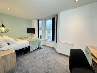 a bedroom with a bed and a window at Sleeps 12 TV in Every Room 6 Bedrooms in Liverpool