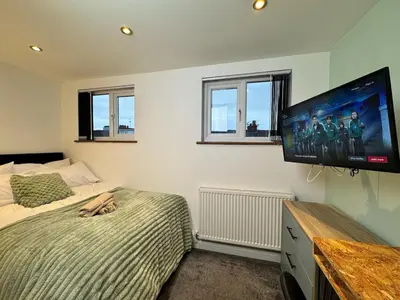 a bedroom with a bed and a flat screen tv at Sleeps 12 TV in Every Room 6 Bedrooms in Liverpool
