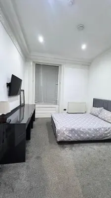 a bedroom with a bed and a desk and a television at Fulwoodroomz in Preston