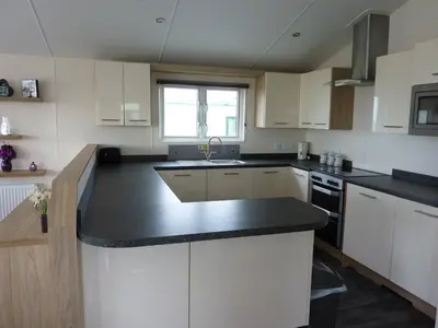 a kitchen with white cabinets and a black counter top at Shrimp Shack in Heysham