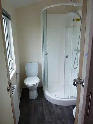 a bathroom with a toilet and a glass shower at Shrimp Shack in Heysham