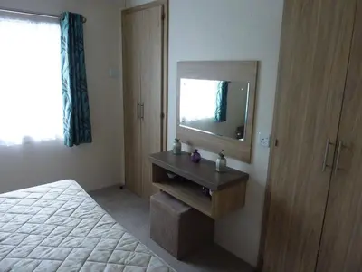 a bedroom with a bed and a dresser with a mirror at Shrimp Shack in Heysham