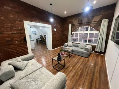 a living room with two couches and a brick wall at Prime City Apt with Parking - Steps to Bars & Trains in Liverpool
