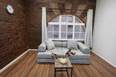 a living room with a couch and a window at Prime City Apt with Parking - Steps to Bars & Trains in Liverpool
