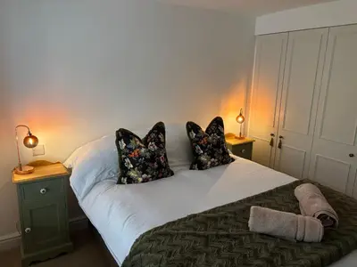 a bedroom with a bed with pillows and two lamps at May Townhouse in Ulverston