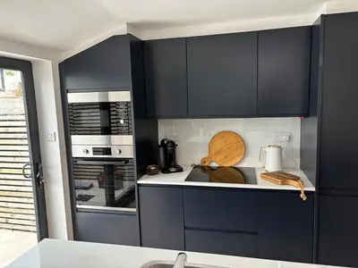 a kitchen with black cabinets and a counter top at May Townhouse in Ulverston