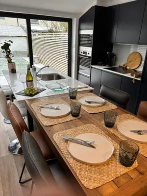 a kitchen with a wooden table with plates on it at May Townhouse in Ulverston