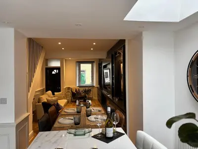 a kitchen and living room with a dining room table at May Townhouse in Ulverston