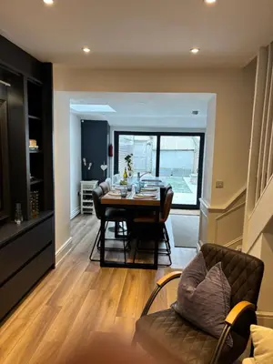 a dining room and living room with a table and chairs at May Townhouse in Ulverston