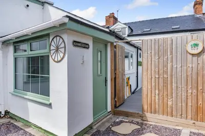 a cottage with a green door and a wooden fence at 3 Bed in Southport oc-h32625 in Southport