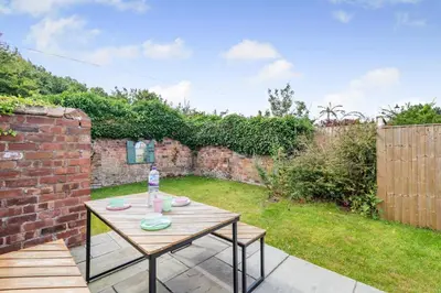 a patio with a wooden table in a garden at 2 Bed in Southport oc-h32626 in Southport