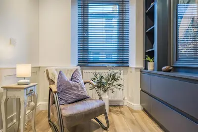 a chair with a purple pillow in a room with windows at 3 Bed in Ulverston oc-m34782 in Ulverston