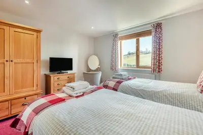 a bedroom with two beds and a tv and a window at 2 Bed in Carnforth oc-s34803 in Warton
