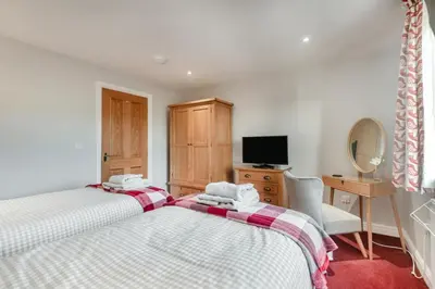 a bedroom with two beds and a desk and a television at 2 Bed in Carnforth oc-s34803 in Warton