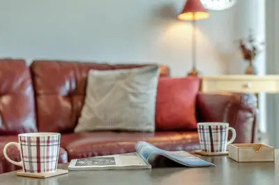 a living room with a leather couch and two coffee cups at 2 Bed in Carnforth oc-s34803 in Warton