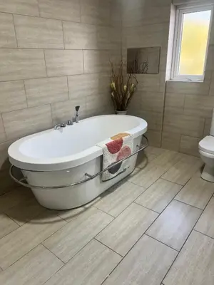 a bath tub in a bathroom with a toilet at Greenways House in Lancaster