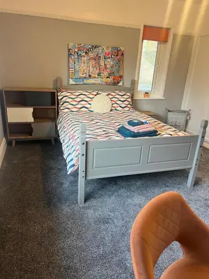 a bedroom with a bed and a window at Greenways House in Lancaster