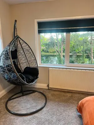 a hanging chair in a room with a window at Greenways House in Lancaster