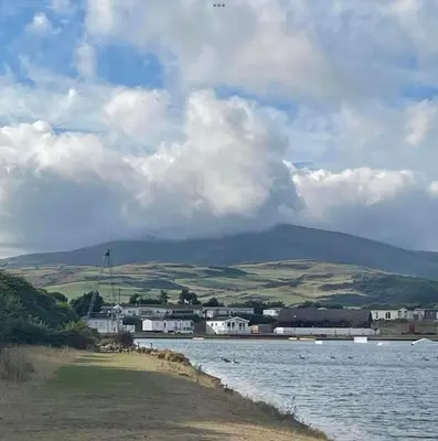 a body of water with a mountain in the background at Lisas Lodge in the Lake District in Millom