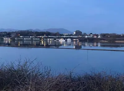 a large body of water with a city in the background at Lisas Lodge in the Lake District in Millom