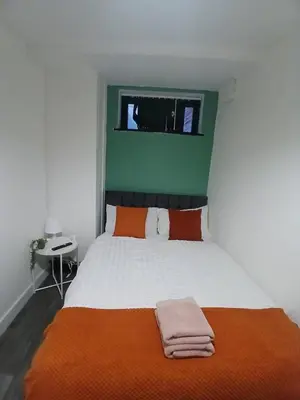 a bedroom with a large bed with an orange blanket at 12B Classy Bedroom in a Shared home at Pembroke in Liverpool