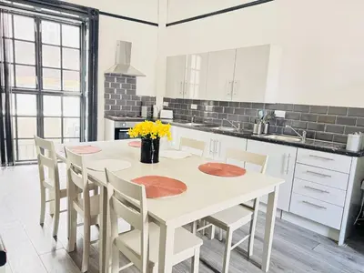 a white kitchen with a white table and chairs at 12B Classy Bedroom in a Shared home at Pembroke in Liverpool