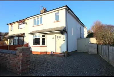 a large white house with a fence in front of it at Golf open - walking distance in Ainsdale