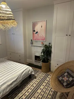 a bedroom with a bed and a chair and a fireplace at Golf open - walking distance in Ainsdale