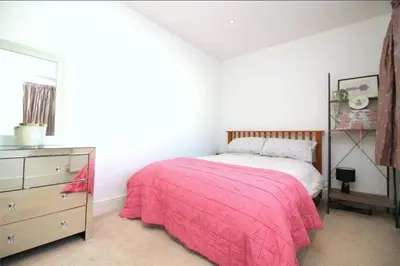 a bedroom with a pink bed and a dresser at Golf open - walking distance in Ainsdale